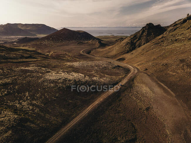 Desde arriba coche conduciendo en seco camino rural en las montañas. - foto de stock