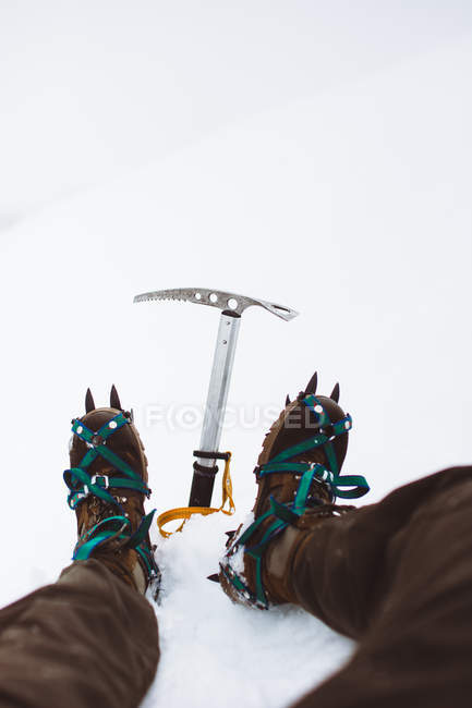 Primer plano de las botas de escalador en la colina nevada - foto de stock