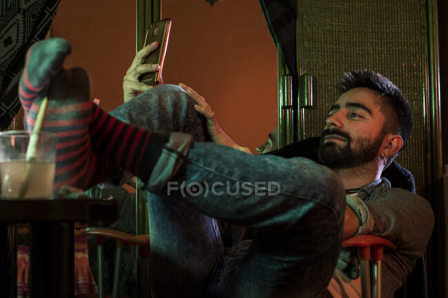 Artista homem com smartphone na cadeira — Fotografia de Stock