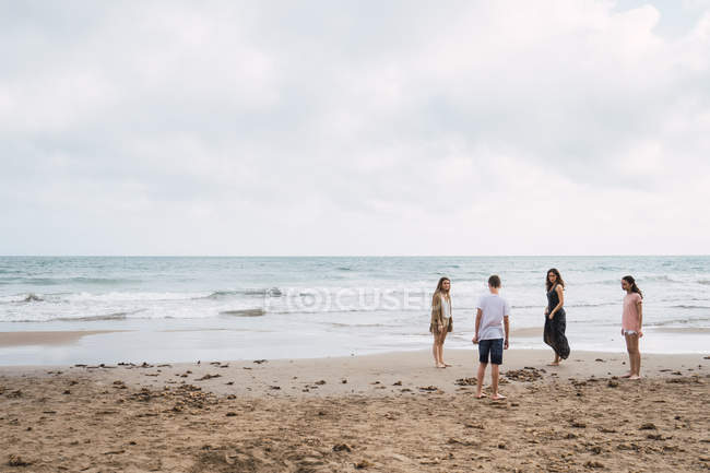 Femme et les adolescents marchant sur la plage de sable — Photo de stock