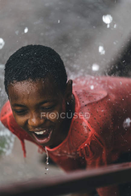 CAMEROON - AFRICA - APRIL 5, 2018: Ethnic girl standing under water drops — Stock Photo