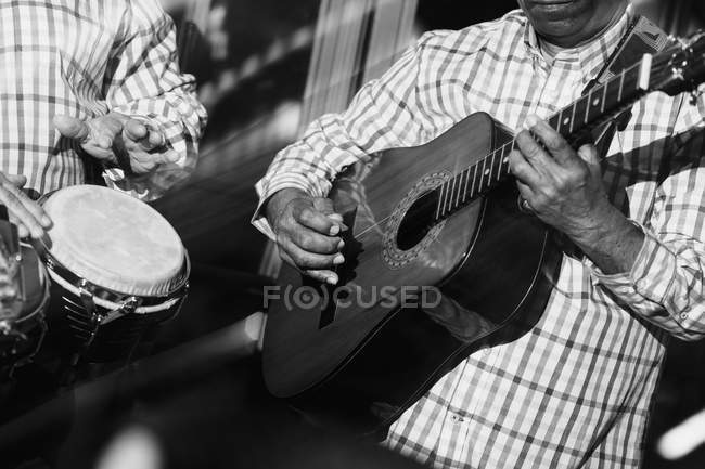 Músicos tocando guitarra e bateria em boate, tiro preto e branco com longa exposição — Fotografia de Stock