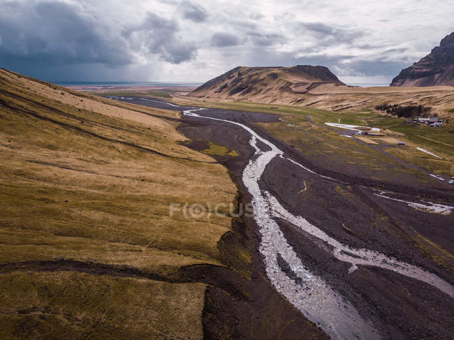 Montañas y valle con río bajo el cielo nublado, Islandia - foto de stock
