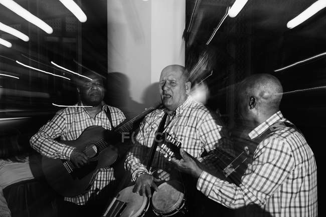 Trio musical cubain agissant en boîte de nuit, plan noir et blanc avec une longue exposition — Photo de stock