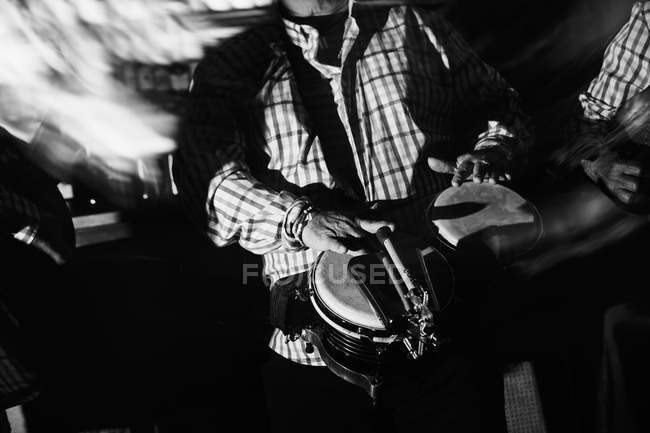 Музыканты, играющие на гитаре и барабанах в ночном клубе, черно-белый кадр с длительной экспозицией — стоковое фото