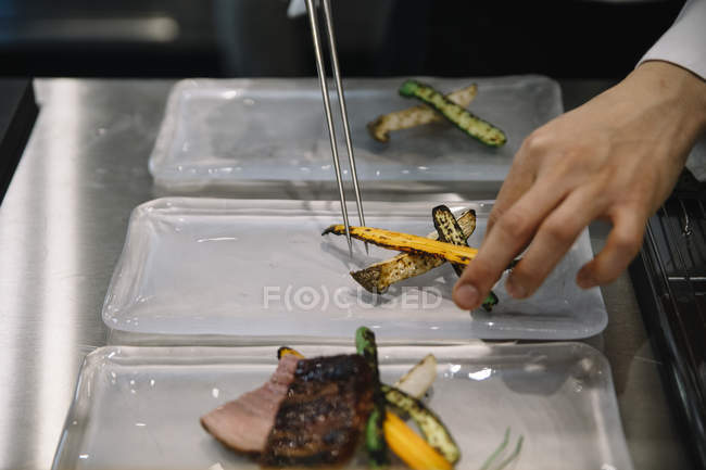 Chef preparing dishes with chopsticks in restaurant — Stock Photo