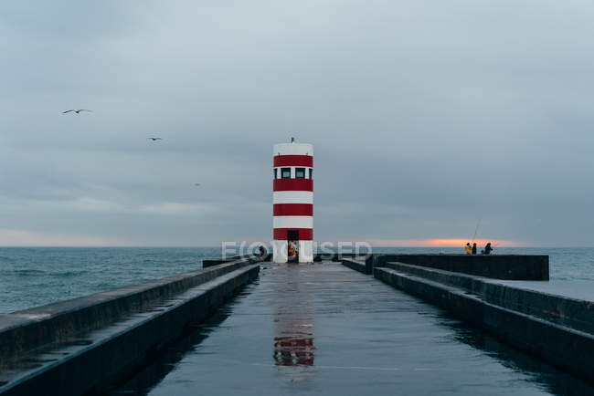 Старий червоний і білий маяк в океані (Порто, Португалія). — стокове фото