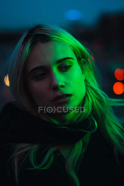 Продумана блондинка дивиться в сутінках — стокове фото