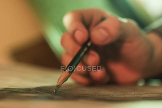 Primer plano de la mano de la persona irreconocible dibujo con lápiz - foto de stock