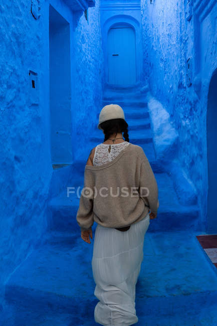 Woman walking on blue dyed street in Morocco — Stock Photo