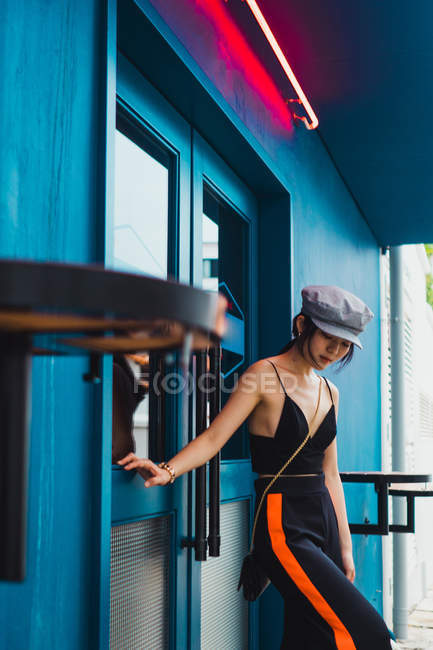 Stylische junge asiatische Frau steht vor der Tür auf der Straße — Stockfoto