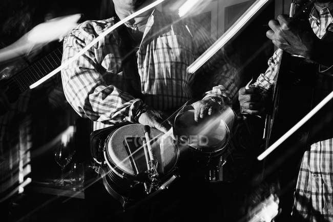 Кубинские музыканты, выступающие в ночном клубе, черно-белый кадр с длительной экспозицией — стоковое фото