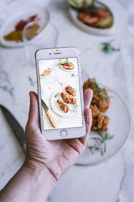 Crop hand taking picture of food — Stock Photo