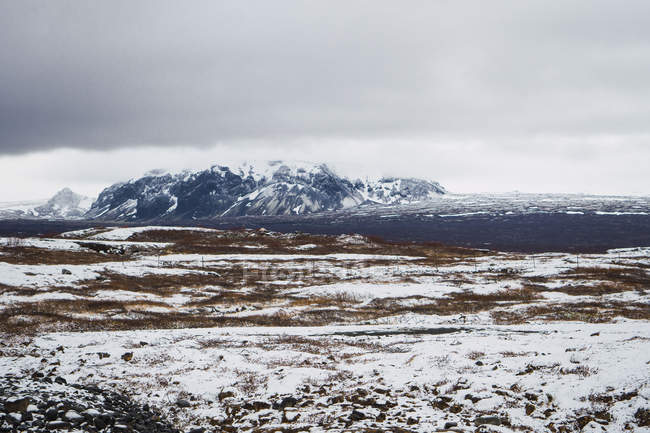 Tranquilo vale nevado com montanhas sob céu nublado, Islândia — Fotografia de Stock