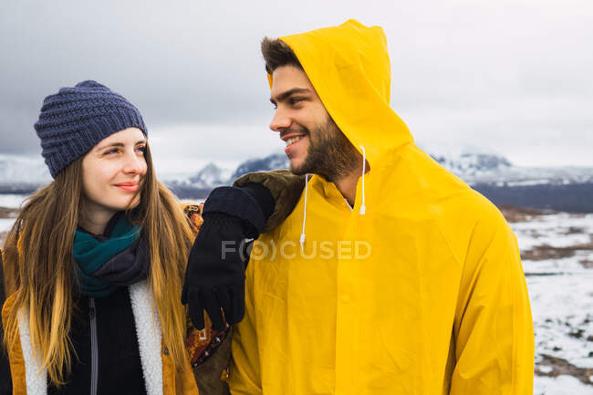 Content man and woman standing together and smiling on background of cold mountains of Iceland. — Stock Photo