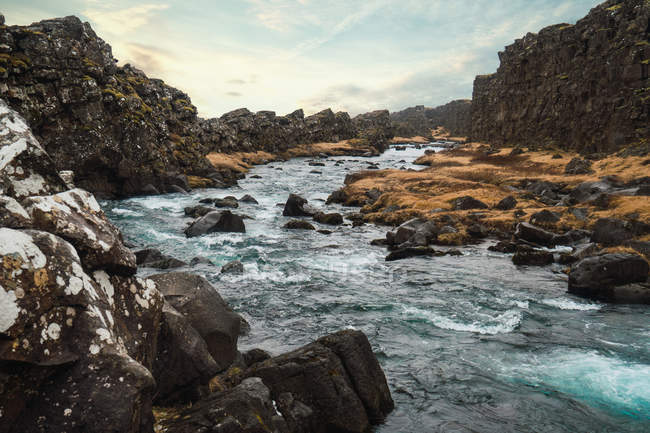 Córrego de água fluindo entre rochas e pedras de vale na Islândia — Fotografia de Stock