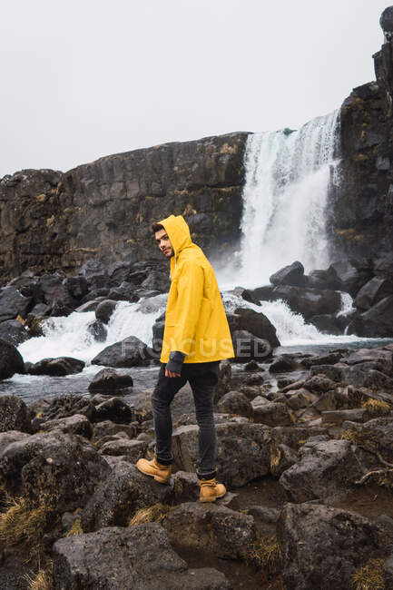 Tourist exploring rocky waterfall — Stock Photo