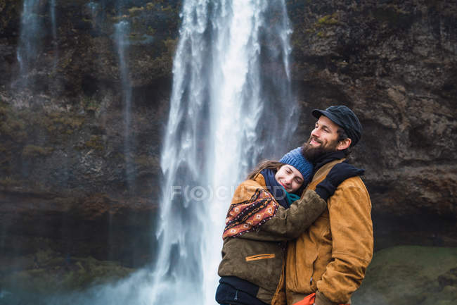 Coppia in piedi davanti alla cascata insieme — Foto stock