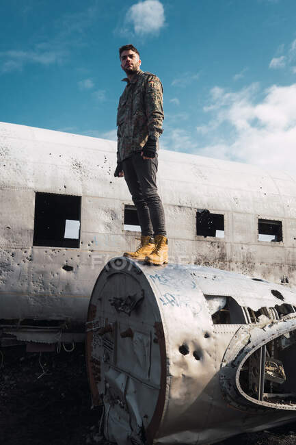 Uomo in piedi su vecchio aereo distrutto — Foto stock