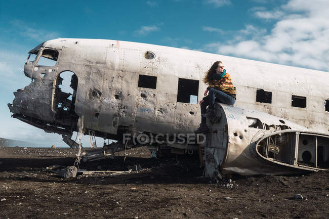 Mulher sentada no velho avião destruído — Fotografia de Stock