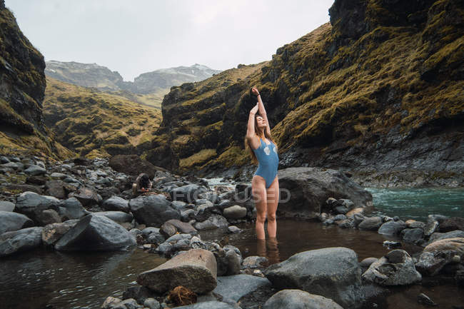 Молодая женщина в купальнике стоит в горной реке — стоковое фото