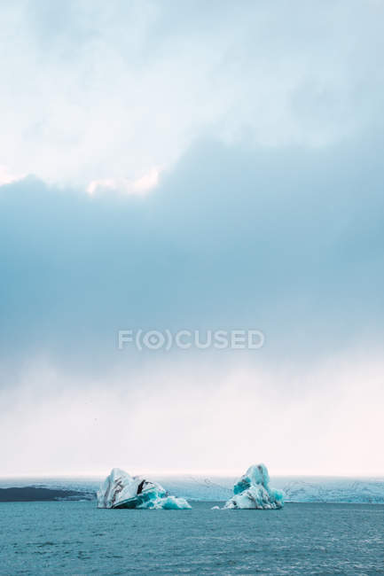 Vista lejana de glaciares en agua azul del océano - foto de stock