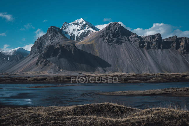 Valle con montañas cubiertas de nieve en día soleado en Islandia - foto de stock