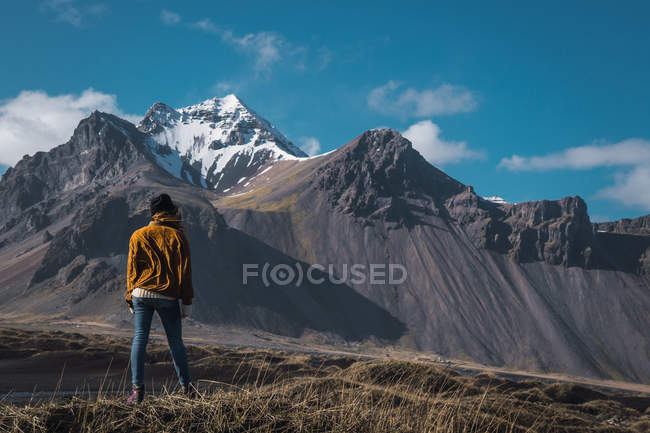 Женщина, стоящая у холодного моря в горах — стоковое фото