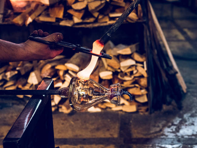 Hände eines unkenntlichen Arbeiters, der Halter für Krug aus geschmolzenem Glas herstellt. — Stockfoto