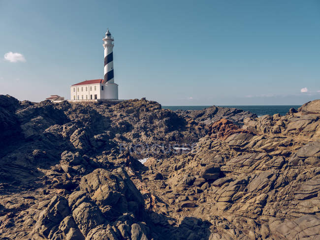 Rocky hill and lighthouse — Stock Photo