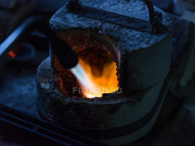 Primer plano de la calefacción de metal en la fábrica de joyas - foto de stock