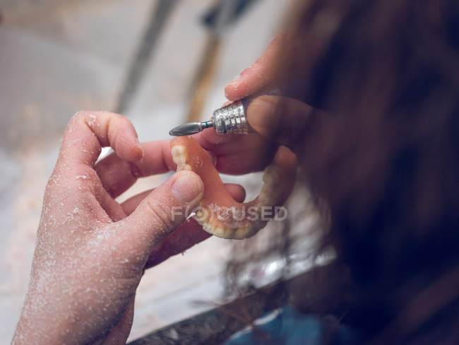 Dental technician polishing teeth — Stock Photo