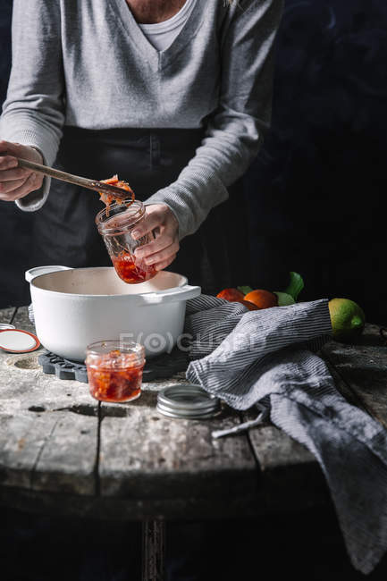 Mulher que prepara o engarrafamento de laranja sangue — Fotografia de Stock