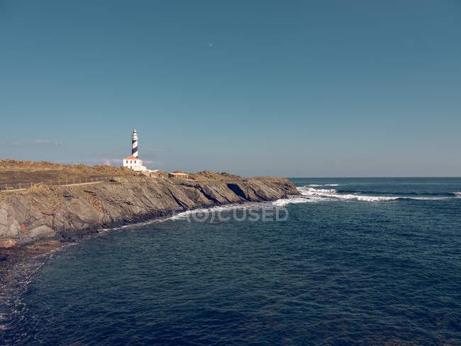 Lighthouse on rocky cliff — Stock Photo