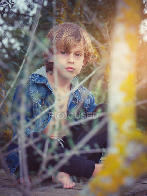 Blonder Junge sitzt auf Holzsteg — Stockfoto