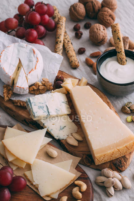 Cheese board with nuts and crostini — Stock Photo