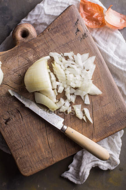 Partly chopped fresh onion on wooden chopping board — Stock Photo