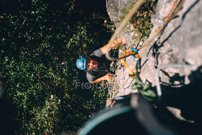 Человек карабкается по скале — стоковое фото