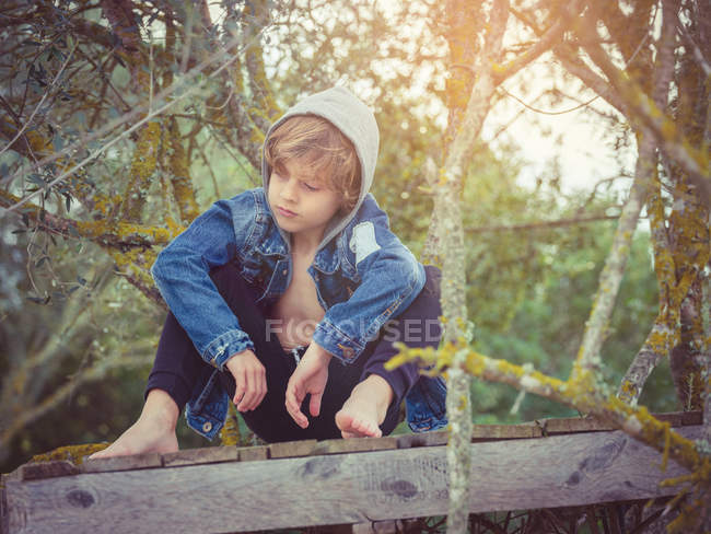 Bambino seduto sul molo di legno — Foto stock