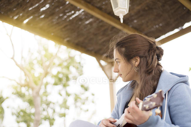 Женщина играет на укелеле — стоковое фото