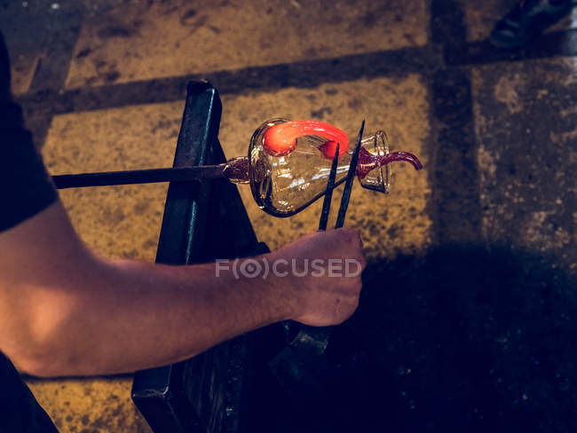Artigiano irriconoscibile che forma titolare su brocca di vetro sulla fabbrica di soffiaggio del vetro . — Foto stock