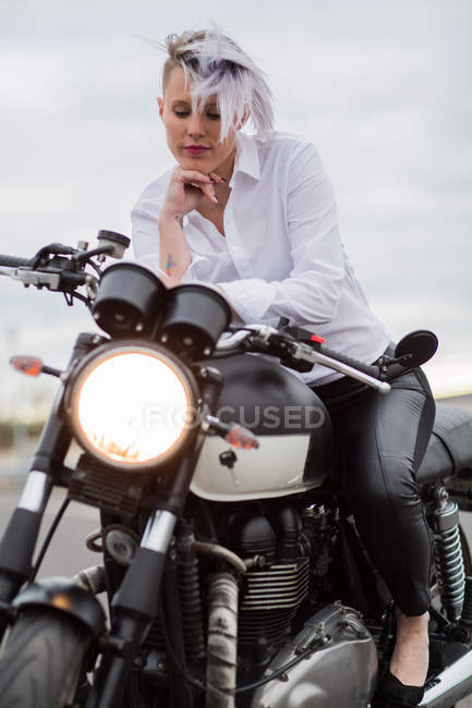 Femme assise sur une moto — Photo de stock