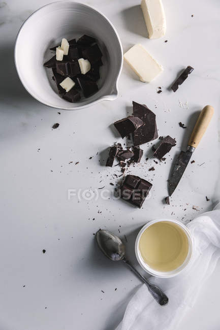 Верхний вид кусочков шоколада и масла, приготовленных на столе . — стоковое фото