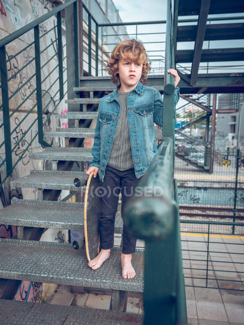 Босоніж хлопчик стоїть на сходах — стокове фото