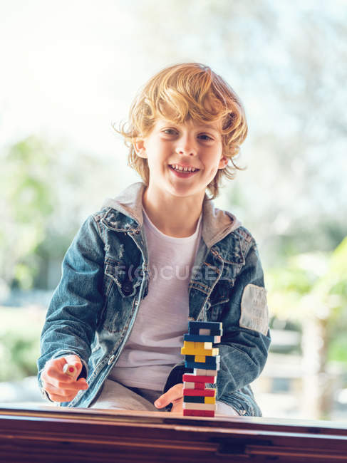 Playing with wooden tower blocks — Stock Photo
