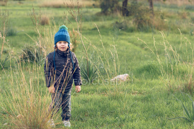 Boy standing in sunny field — Stock Photo