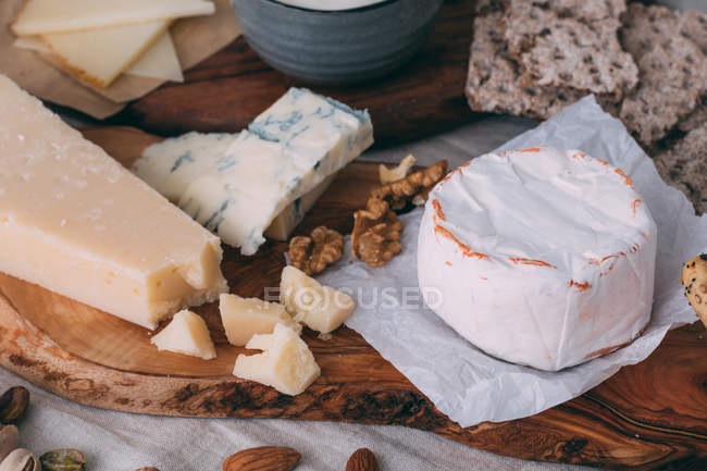 Cheese board with nuts and bread — Stock Photo