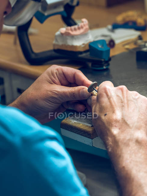 Male hands polishing denture — Stock Photo