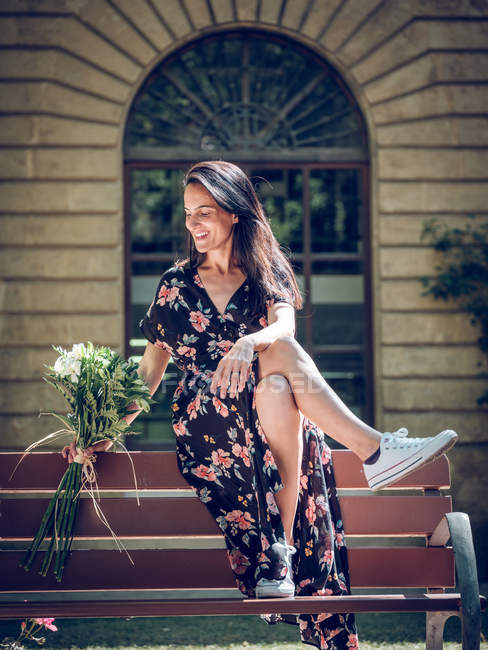 Donna con mazzo di fiori sulla panchina — Foto stock