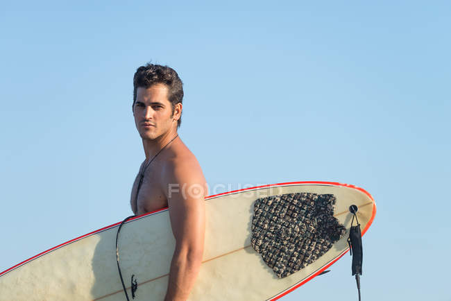 Homem com prancha de surf em pé na costa — Fotografia de Stock